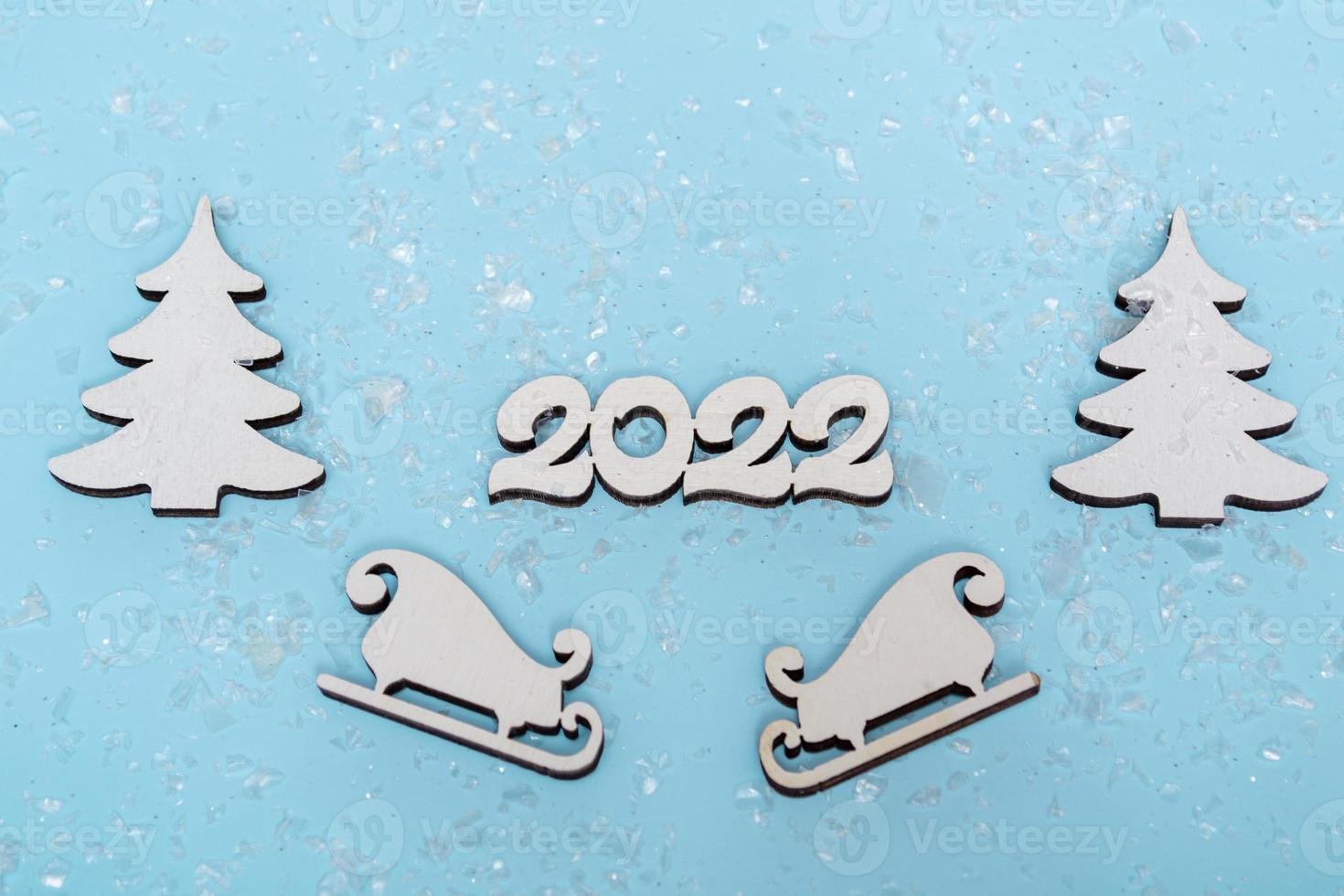 Merry Christmas and Happy New Year banner. Festive poster with a Christmas tree, sledges and snow on a blue background. New year 2022 with close up photo
