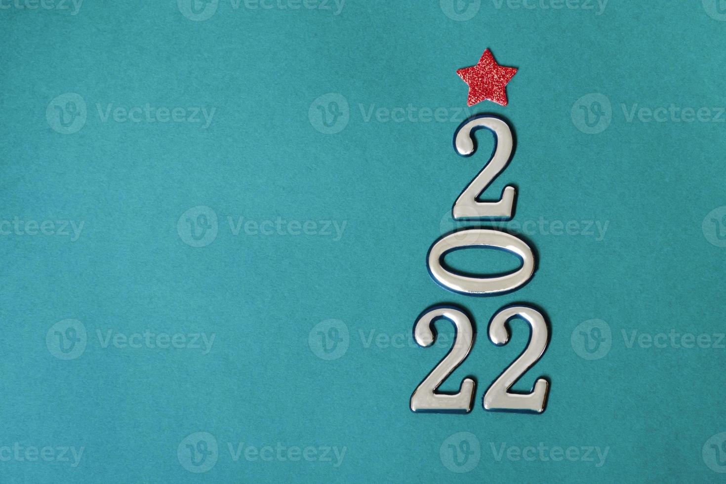 Holiday concept. Christmas background, golden numbers 2022 with red bow and star. Happy New Year. photo