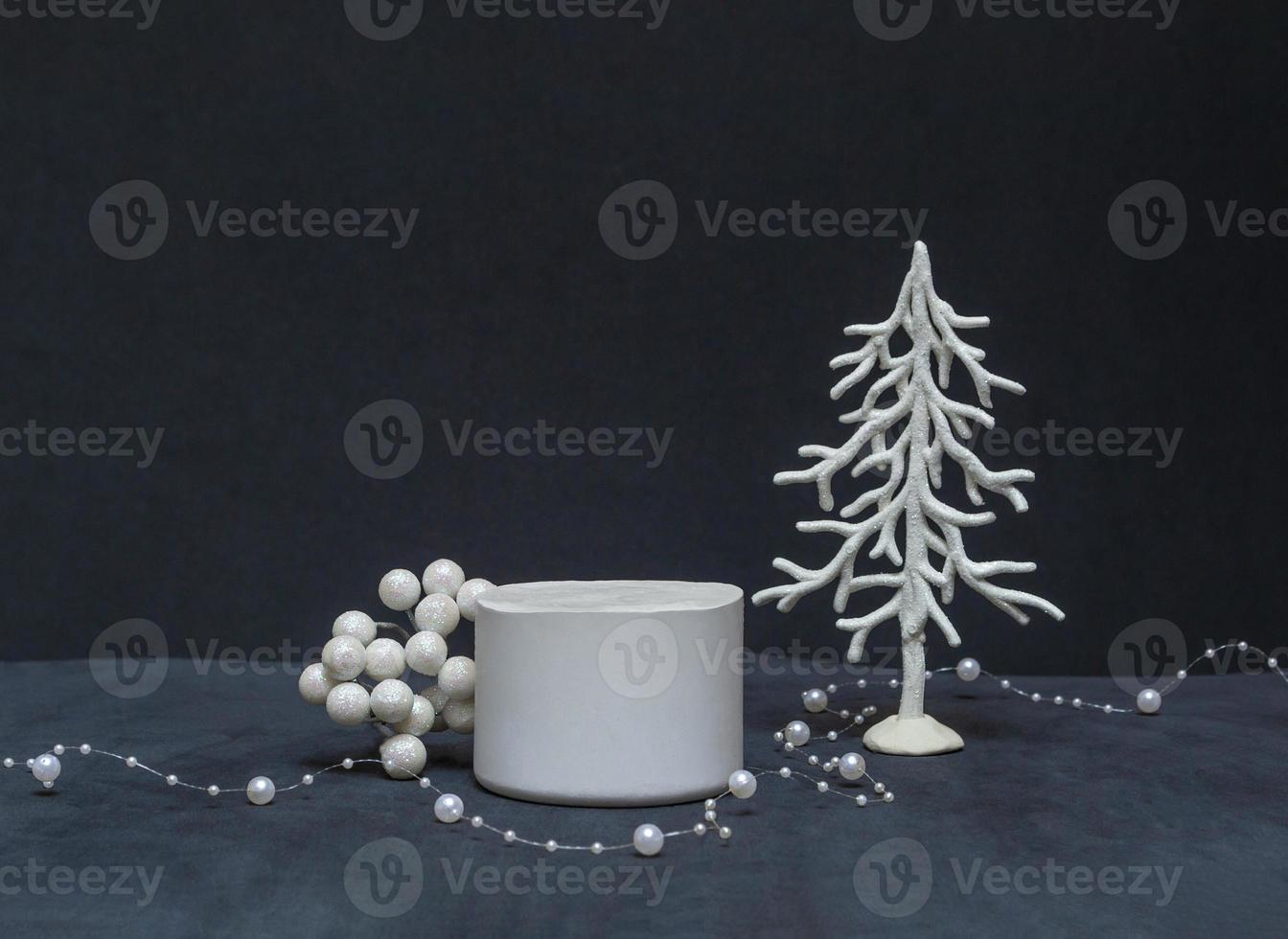 podio para productos y cosméticos con un árbol de Navidad y bayas sobre un fondo negro. cerrar espacio de copia foto