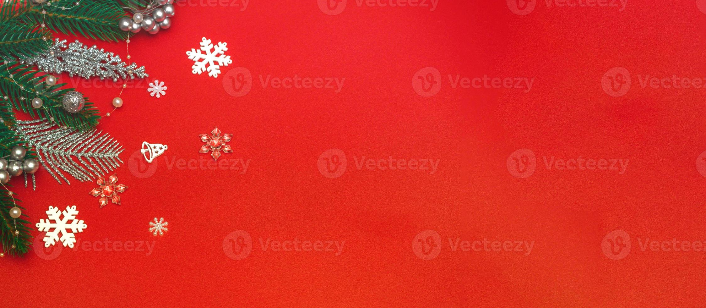 Top view of a flat lay of Christmas decorations on a red background. Concept postcard, announcement, banner. With copy space photo