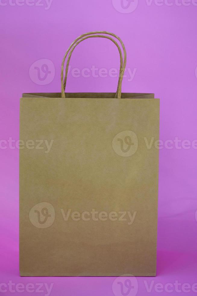 Eco gift bag with copy space on colored background. Vertical photo