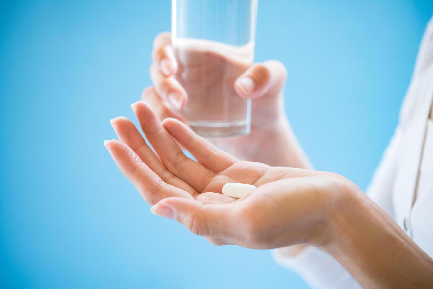 La mano de la mujer vierte las píldoras medicinales de la botella. foto