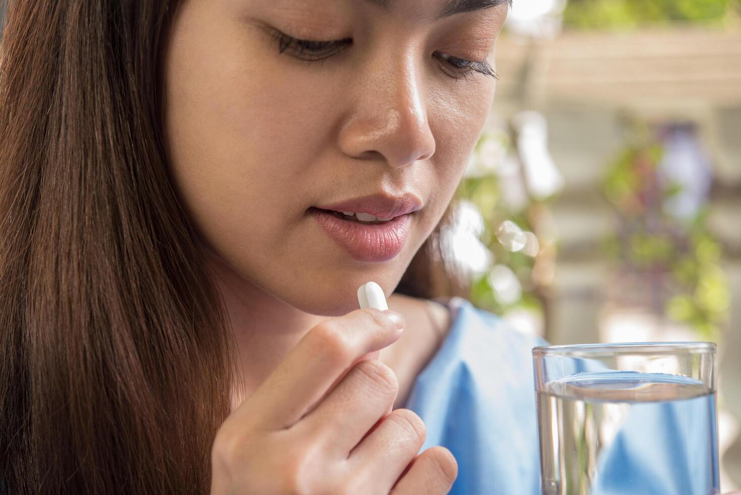 Young woman taking medicine pill after doctor order photo