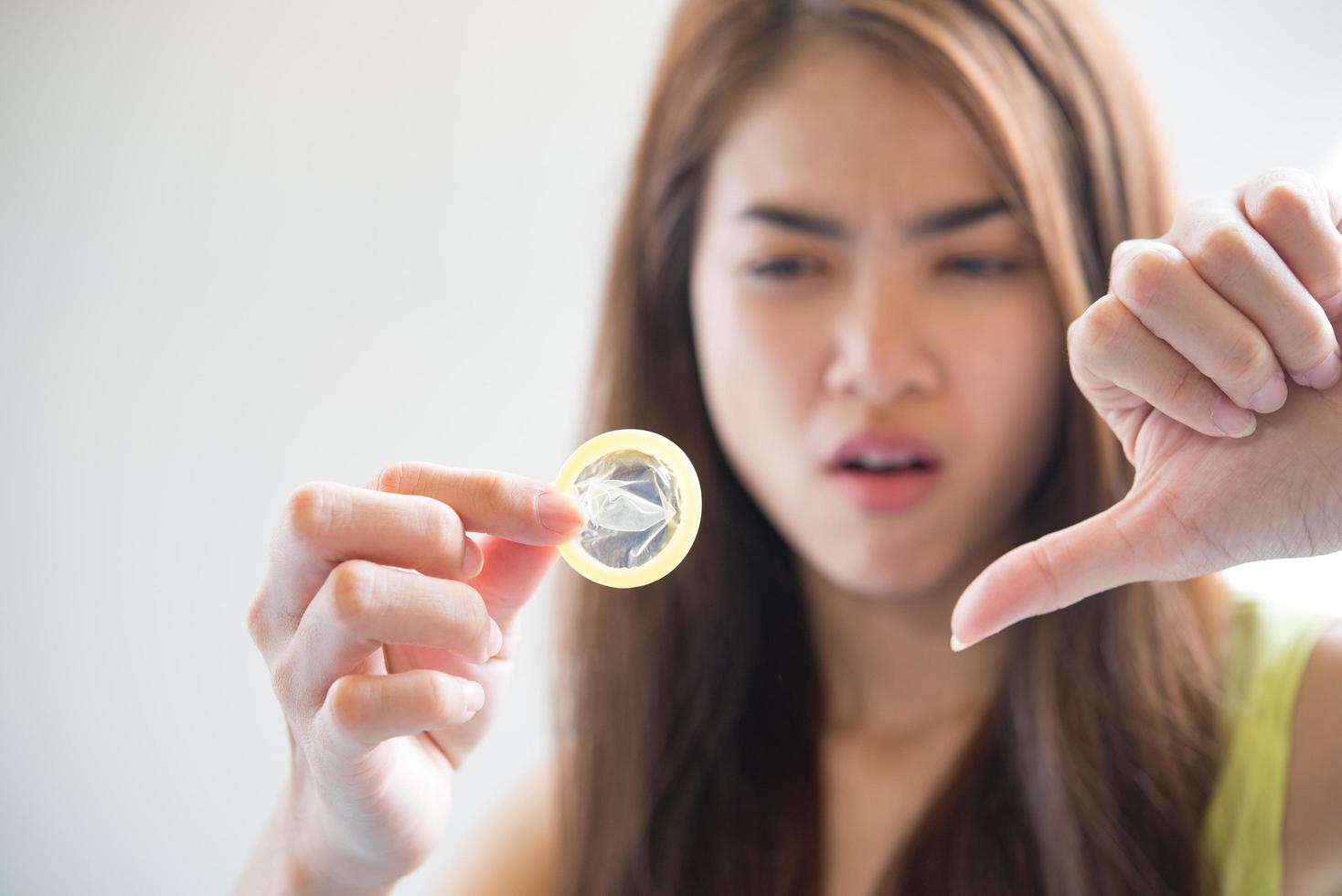 Young woman holding condom prevent pregnancy photo