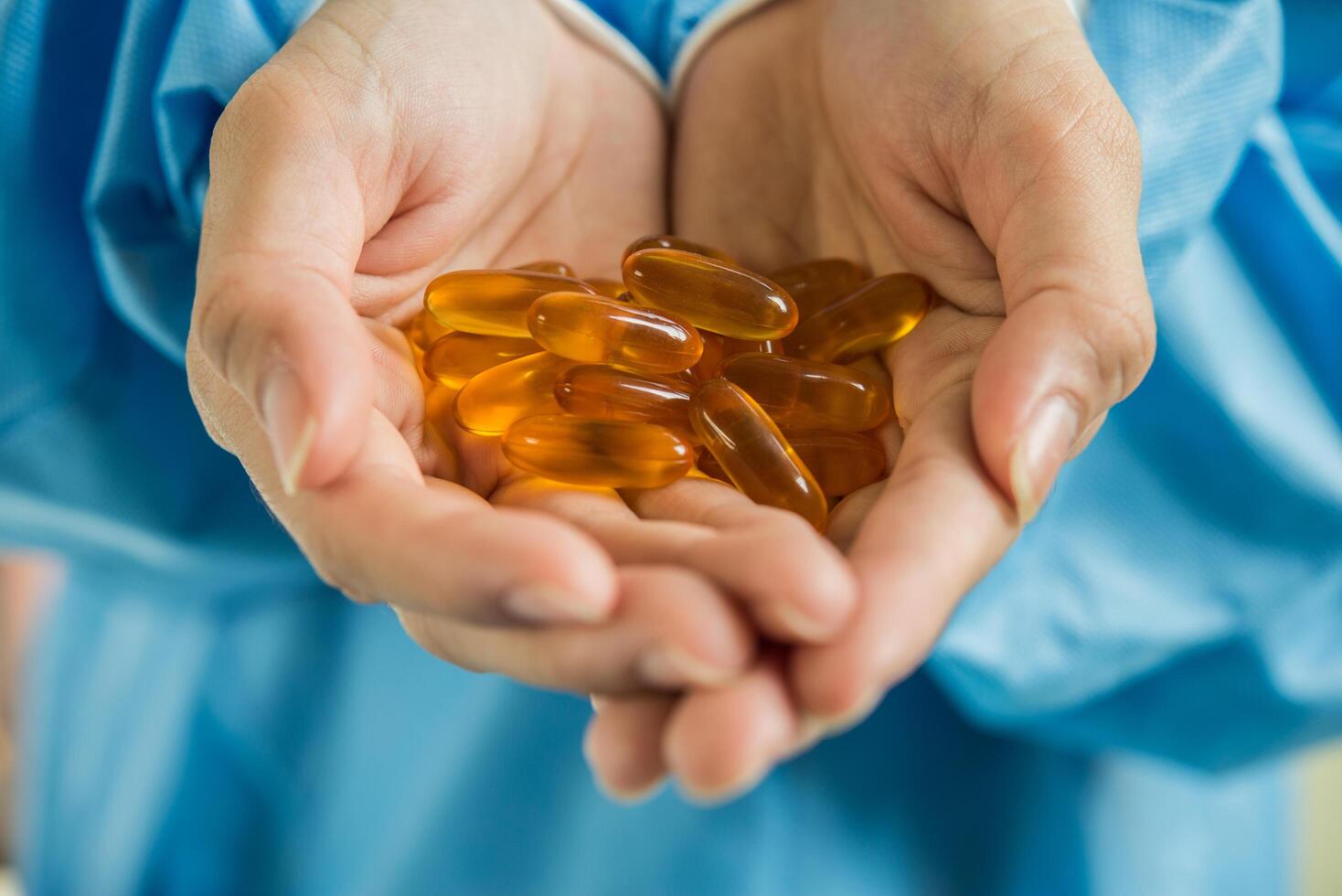 La mano de la mujer vierte las píldoras medicinales de la botella. foto