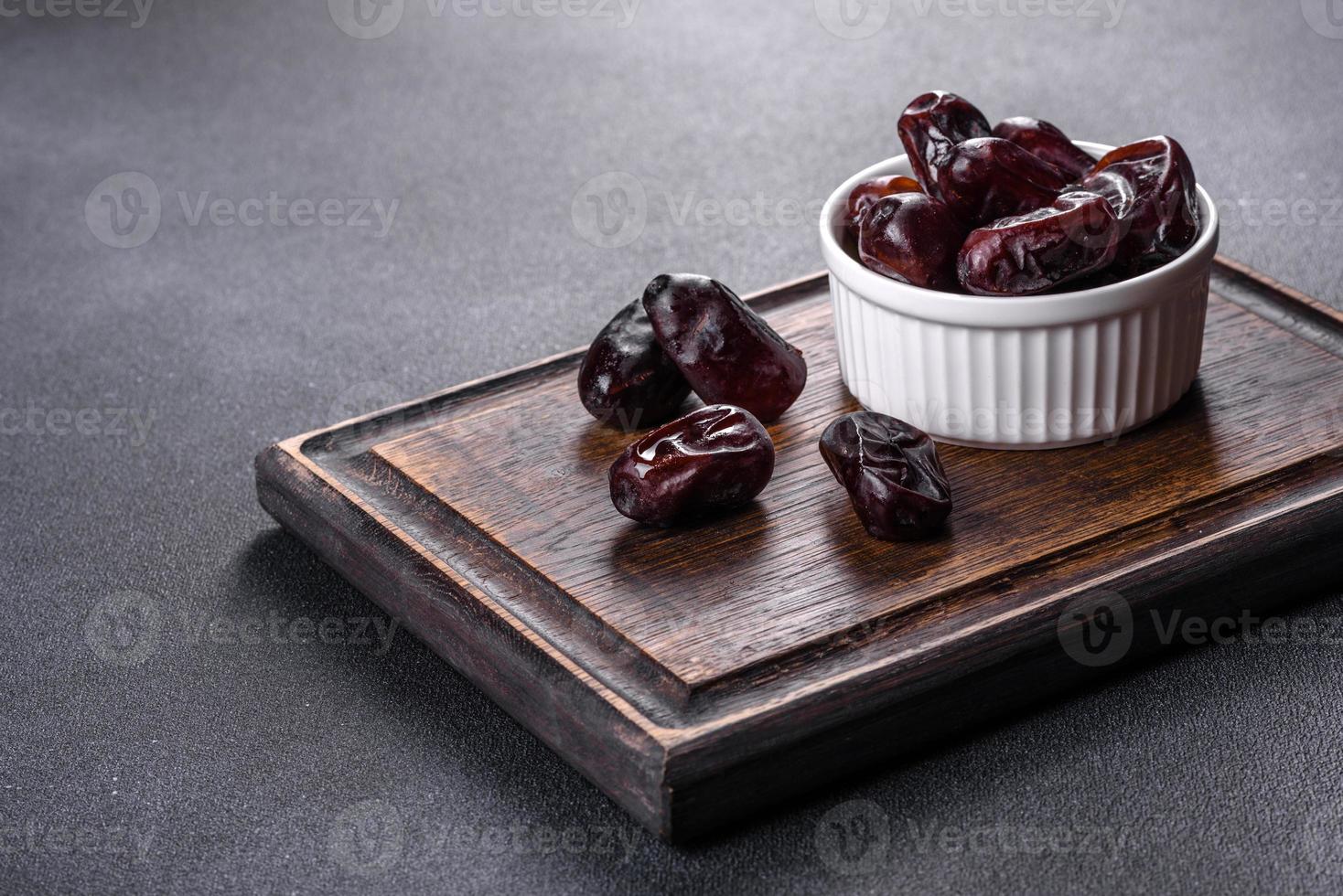 Beautiful delicious dates on a dark concrete background photo