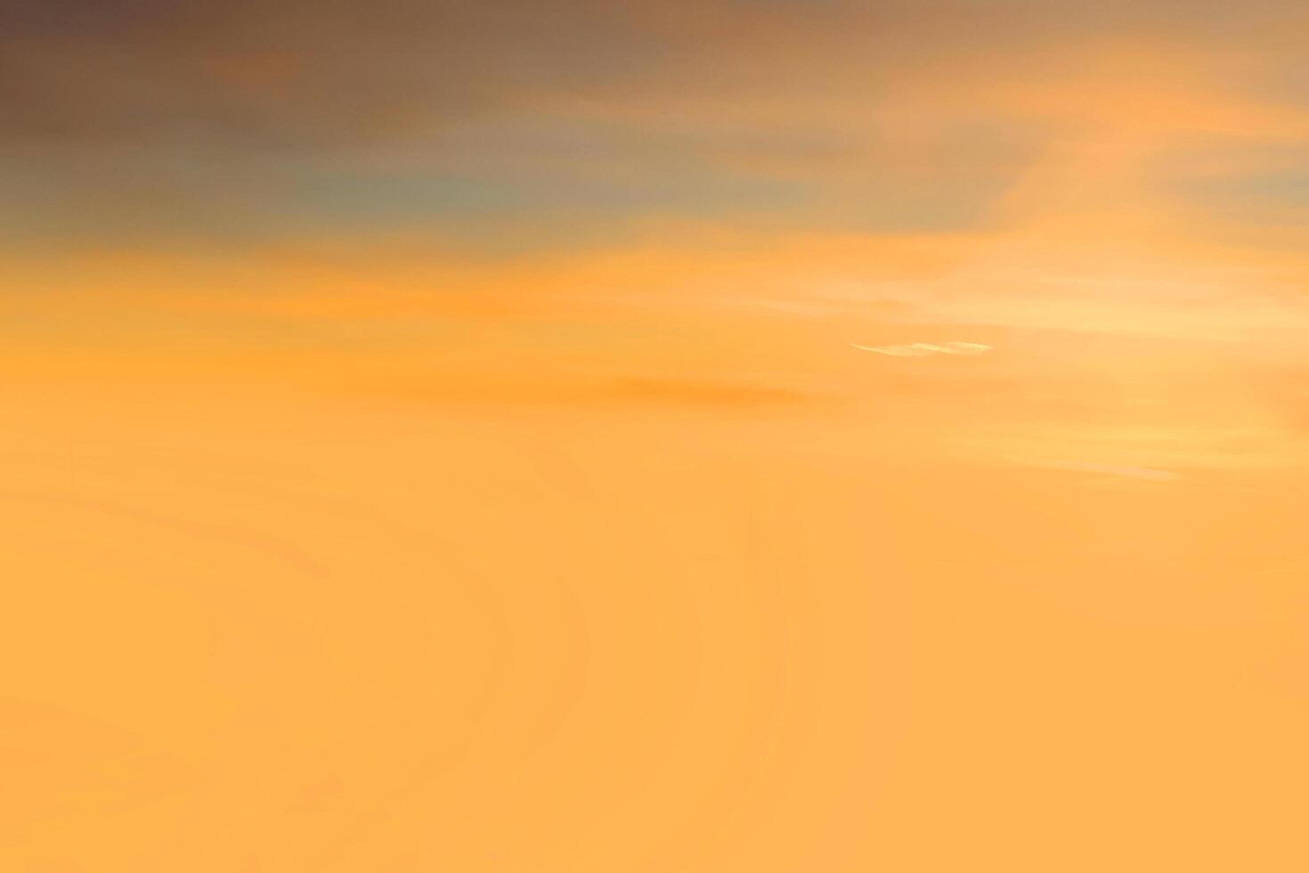 puesta de sol y nube naranja y cielo azul del amanecer con efecto de movimiento de líneas horizontales de nubes en el fondo del sol. foto