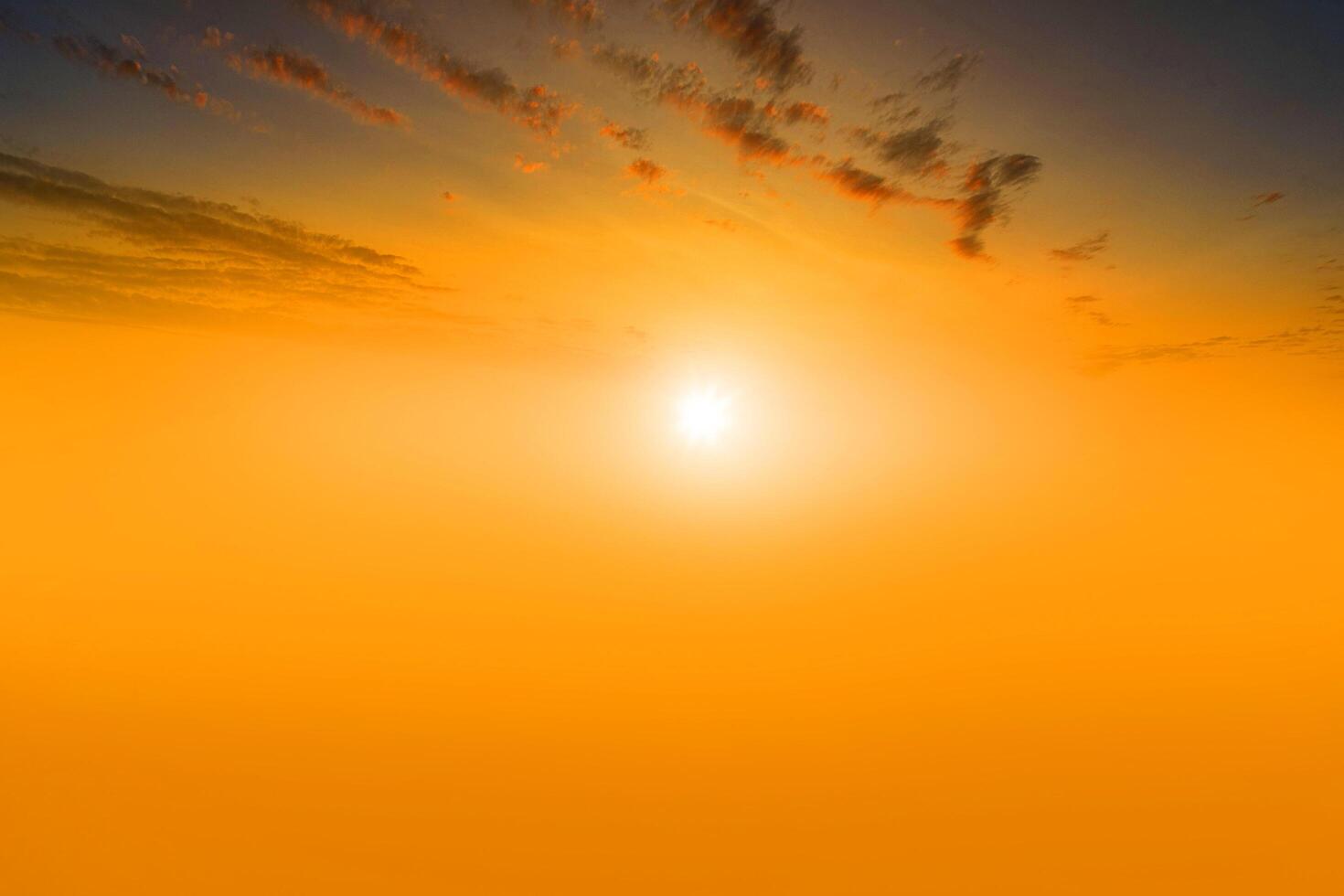 puesta de sol y nube naranja y cielo azul del amanecer con efecto de movimiento de líneas horizontales de nubes en el fondo del sol. foto