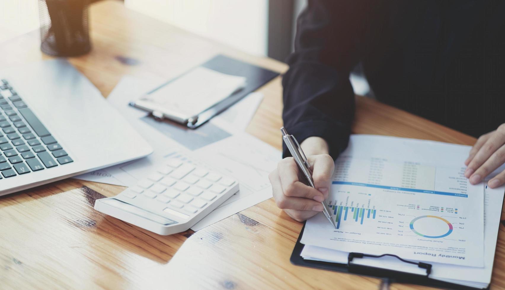 Business woman using calculator for do math finance on wooden desk in office and business working background, tax, accounting, statistics and analytic research concept photo