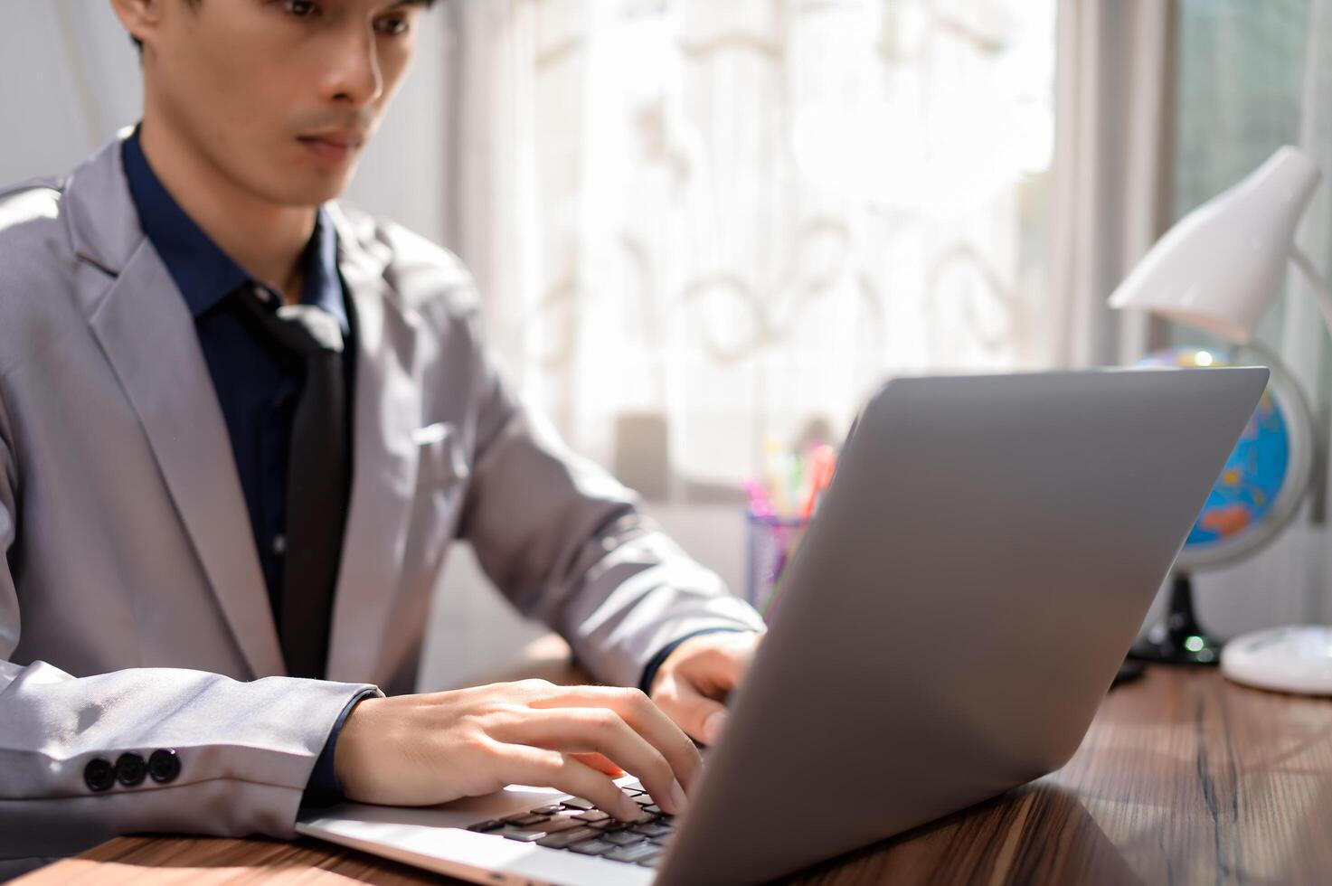 A man in a suit is typing on a laptop photo