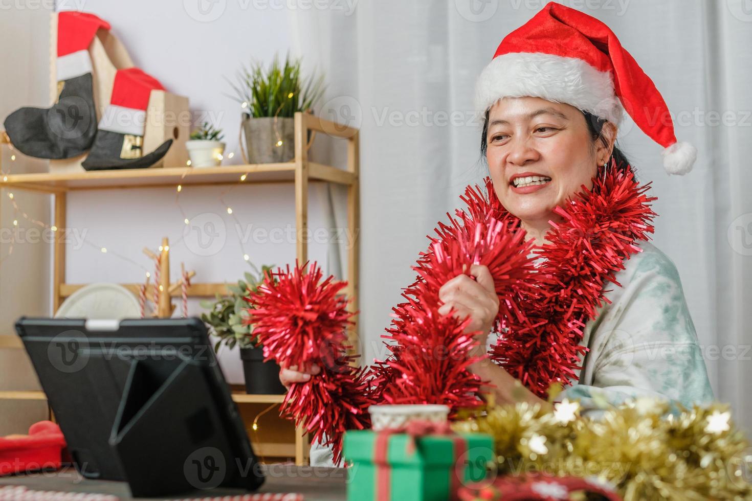 Mujer asiática celebrar el año nuevo y la fiesta de Navidad con amigos de videollamadas de tableta en casa foto
