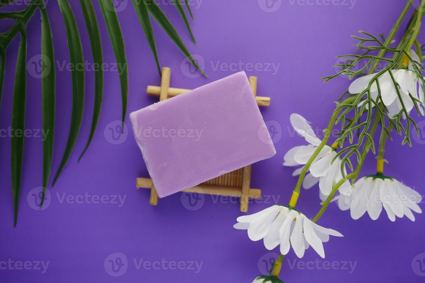 Barra de jabón natural casero sobre fondo violeta foto