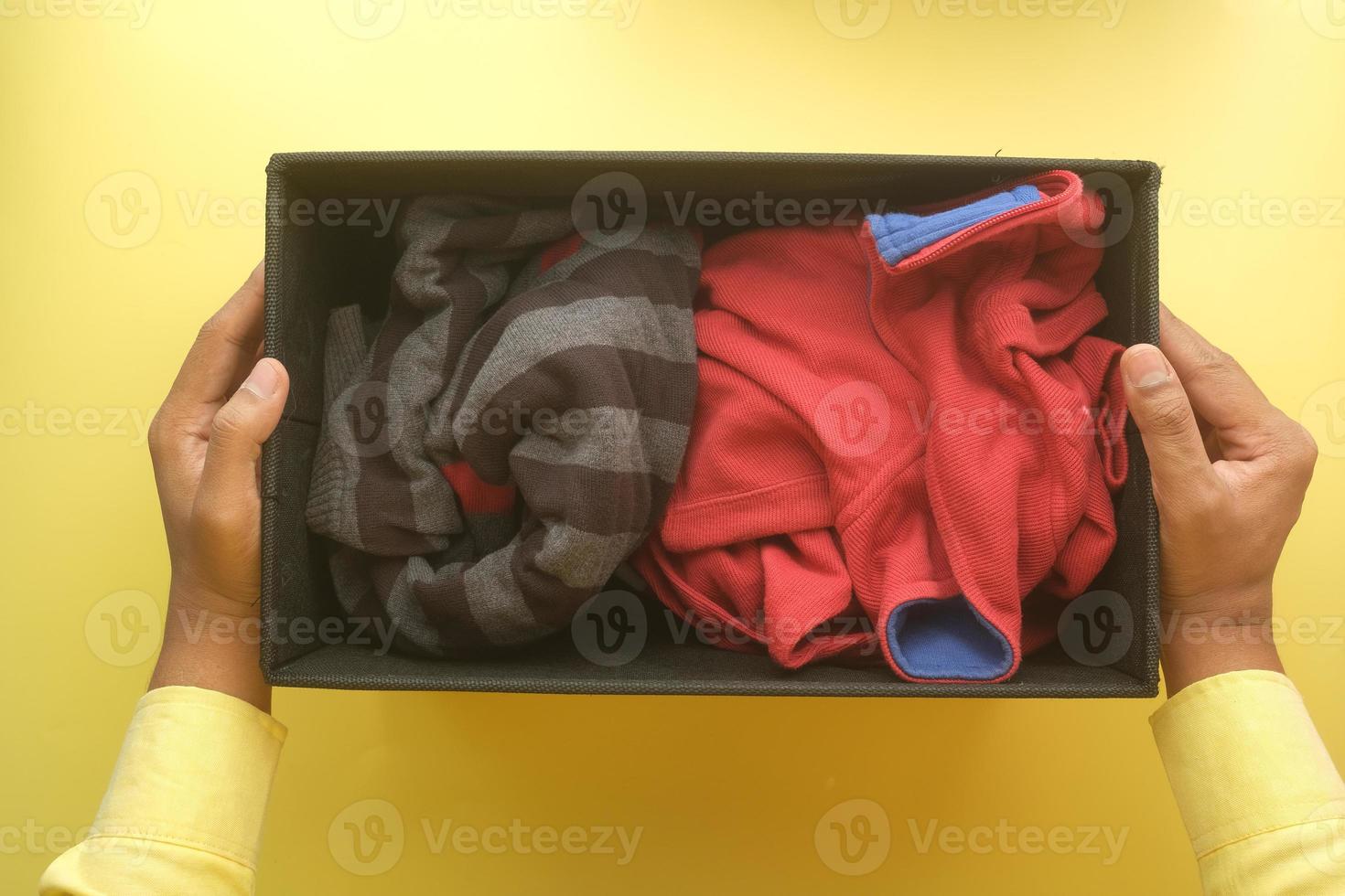 caja de donación con ropa de donación en una mesa de madera. foto