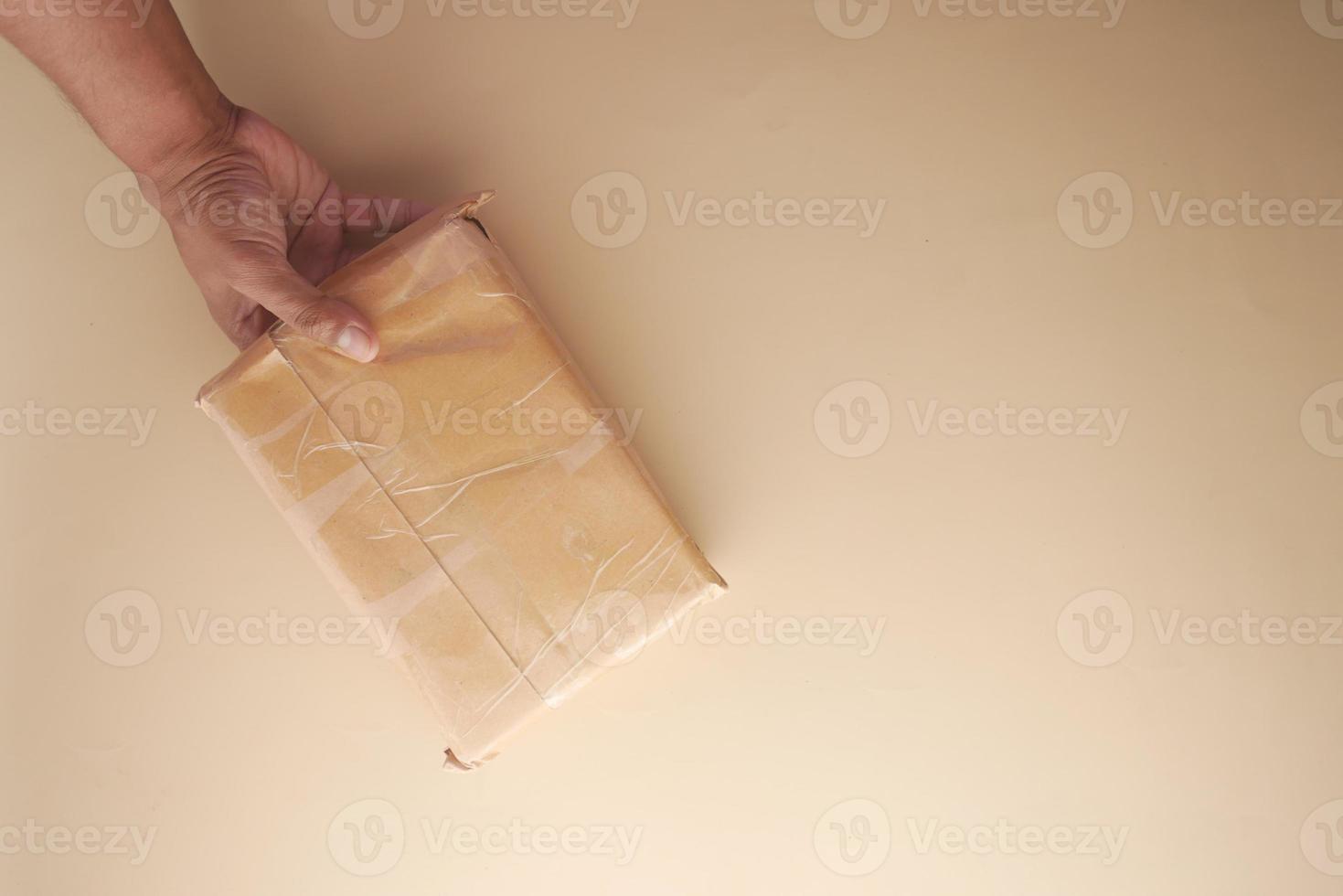 Vista superior de la mano sujete una caja de entrega para envío postal foto