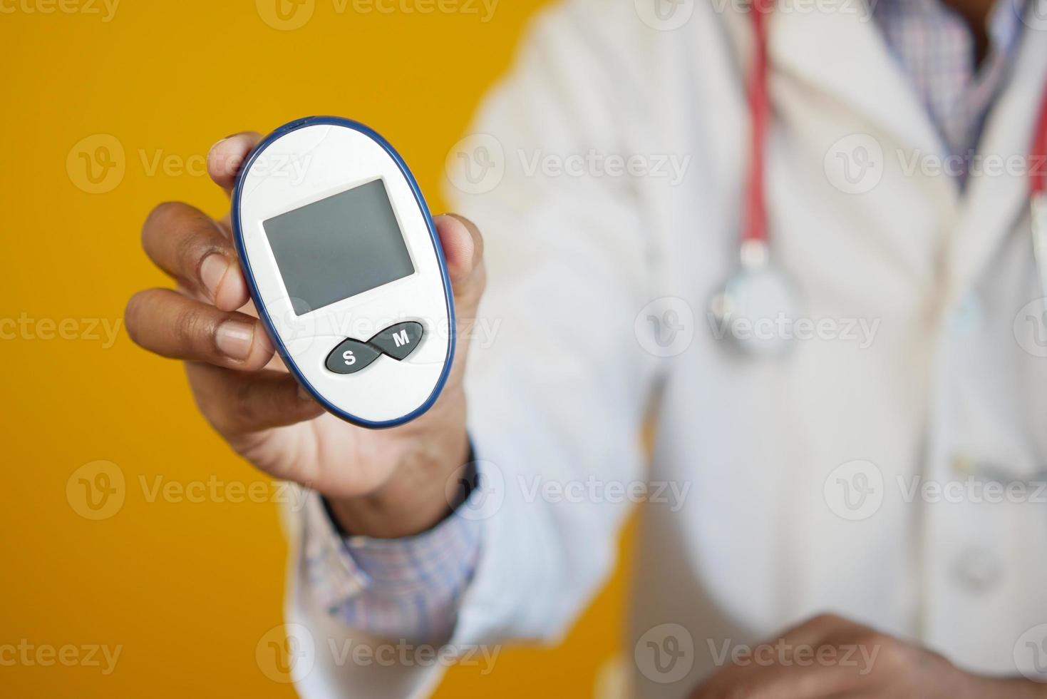 Mano del médico poniendo el medidor de glucosa en una pequeña bolsa foto