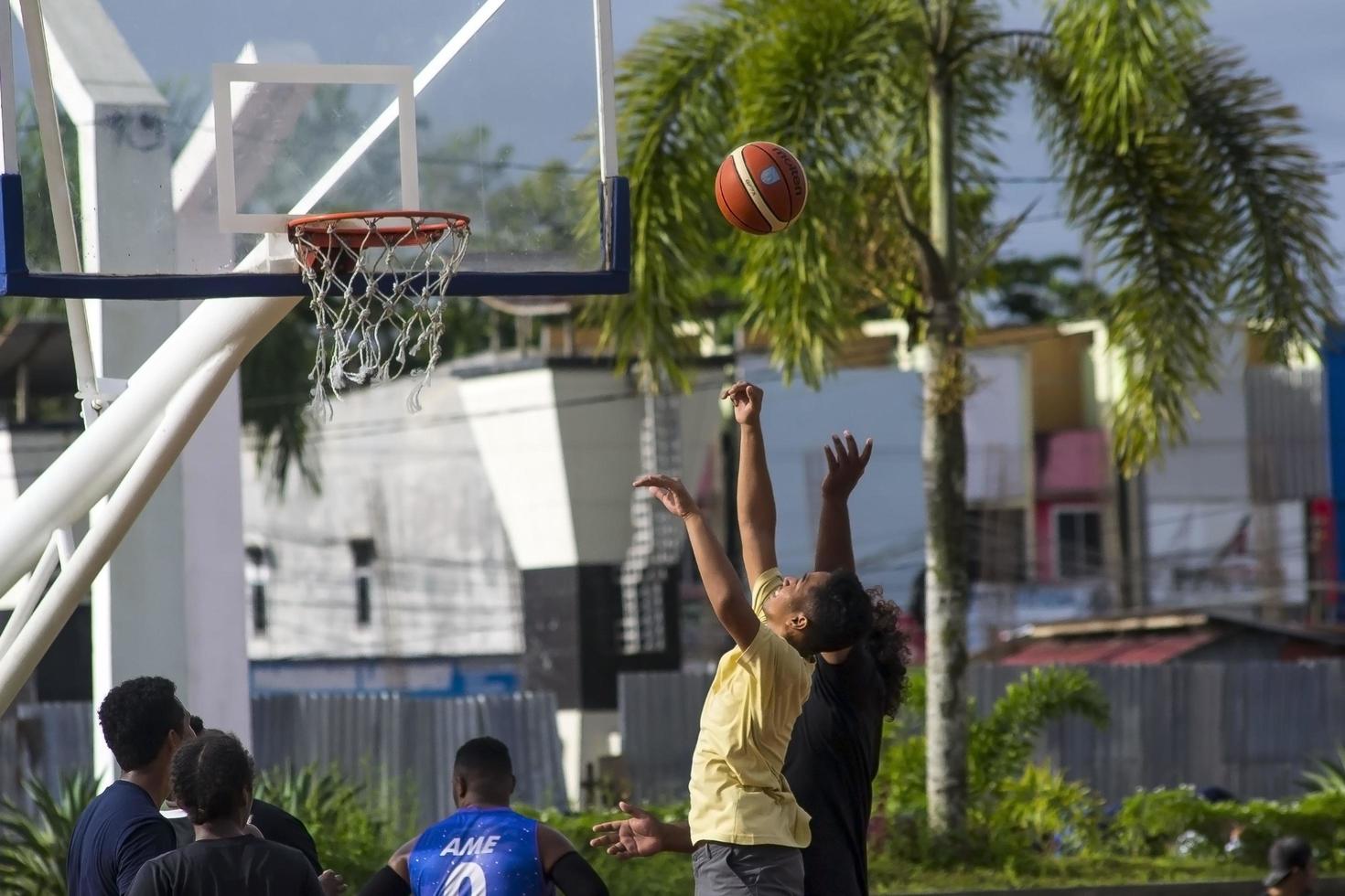 Sorong, West Papua, Indonesia, November 28th 2021. The activities at Aimas town square in Sunday morning. People playing basketball photo