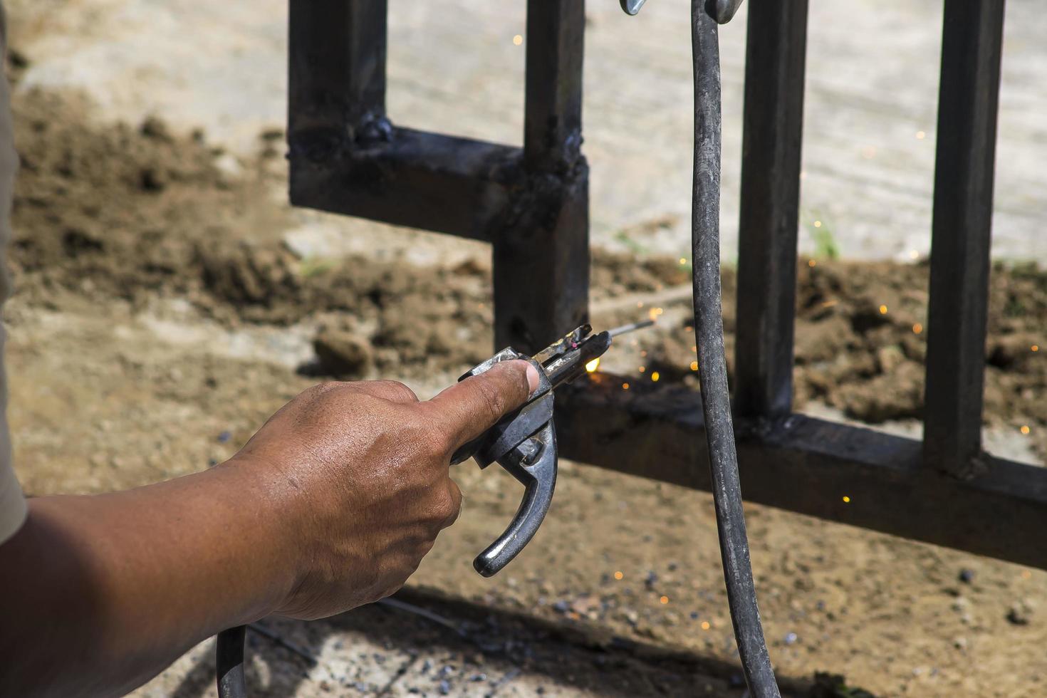 A worker is welding iron without wearing gloves. Light welding work. photo