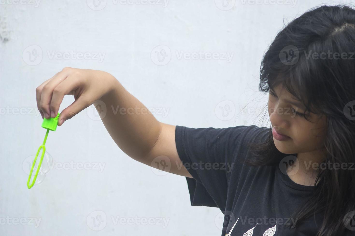 A girl holding a bubble maker and blowing them out. photo