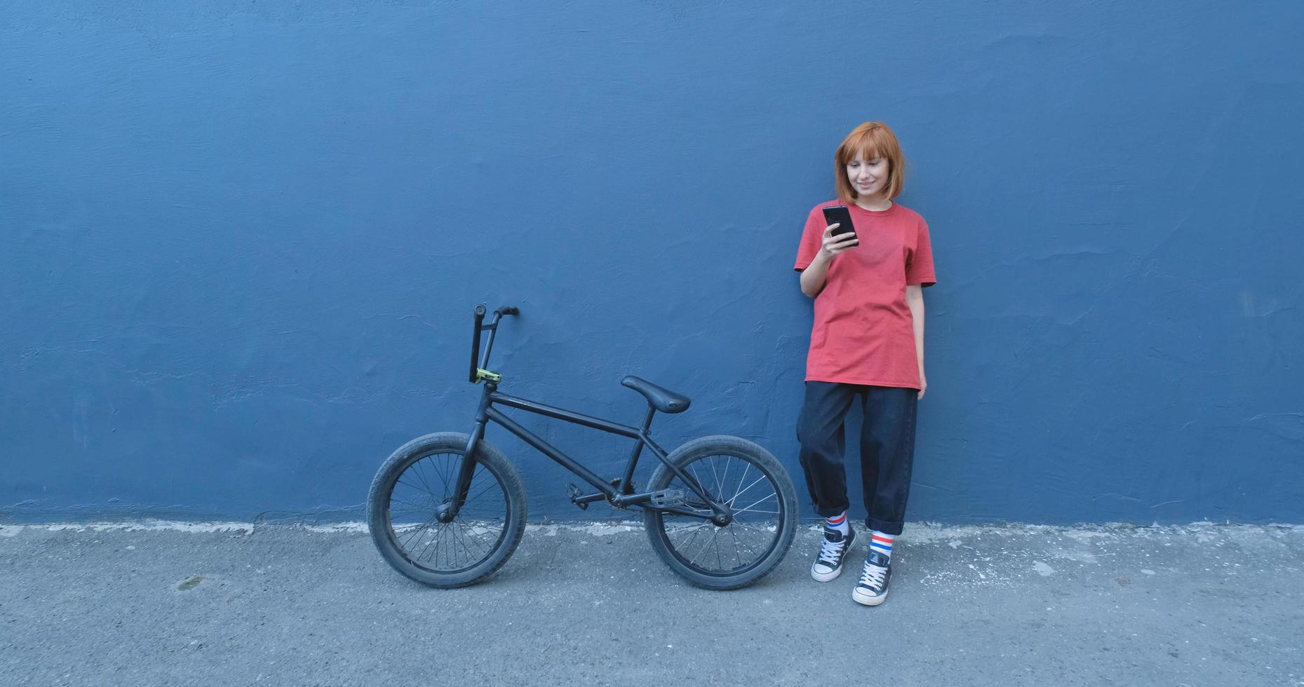 Mujer joven posando con bicicleta BMX al aire libre en la calle foto