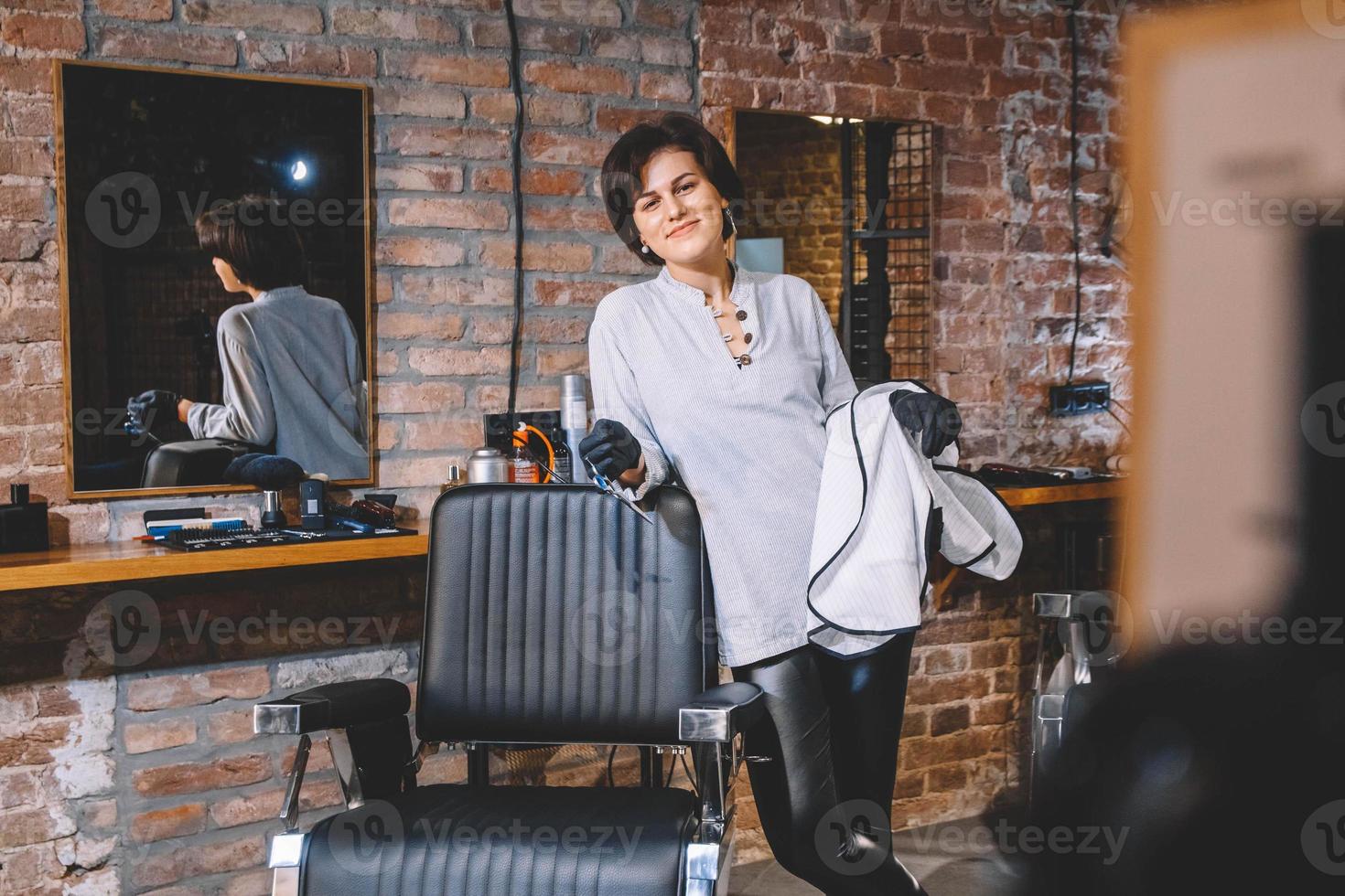 Hairdresser woman with scissors in hand in the barbashop salon photo