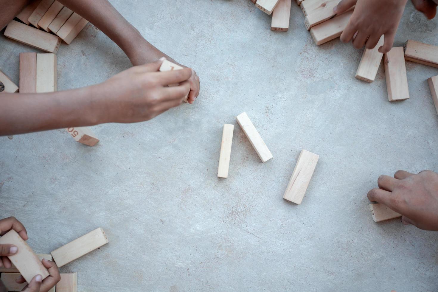 Children playing with wooden blocks on the concrete floor photo