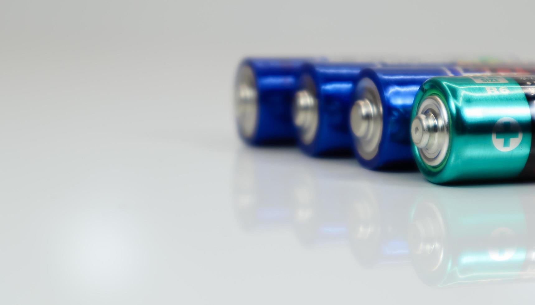 AA alkaline rechargeable batteries on white glossy background with reflection with copy space. photo