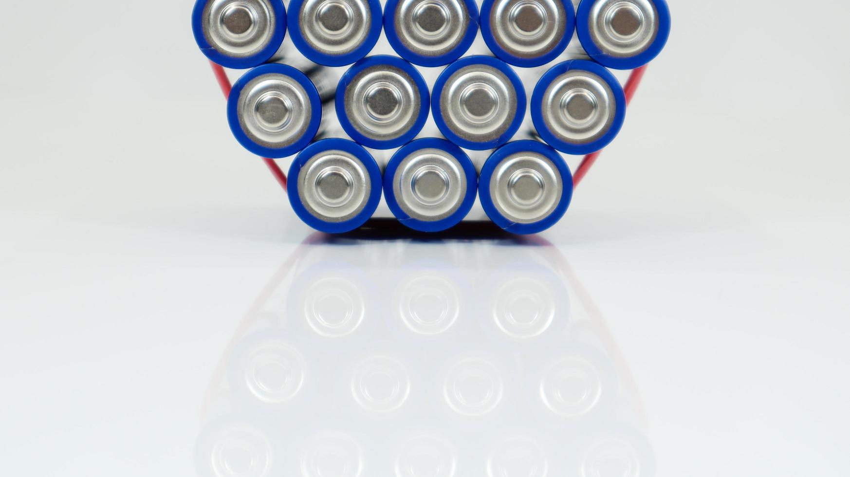 Lots of AA and AAA alkaline batteries on a white background. Ecological recycling concept. The terminals of the disposable batteries are close together and form a beautiful backdrop. Energy source. photo