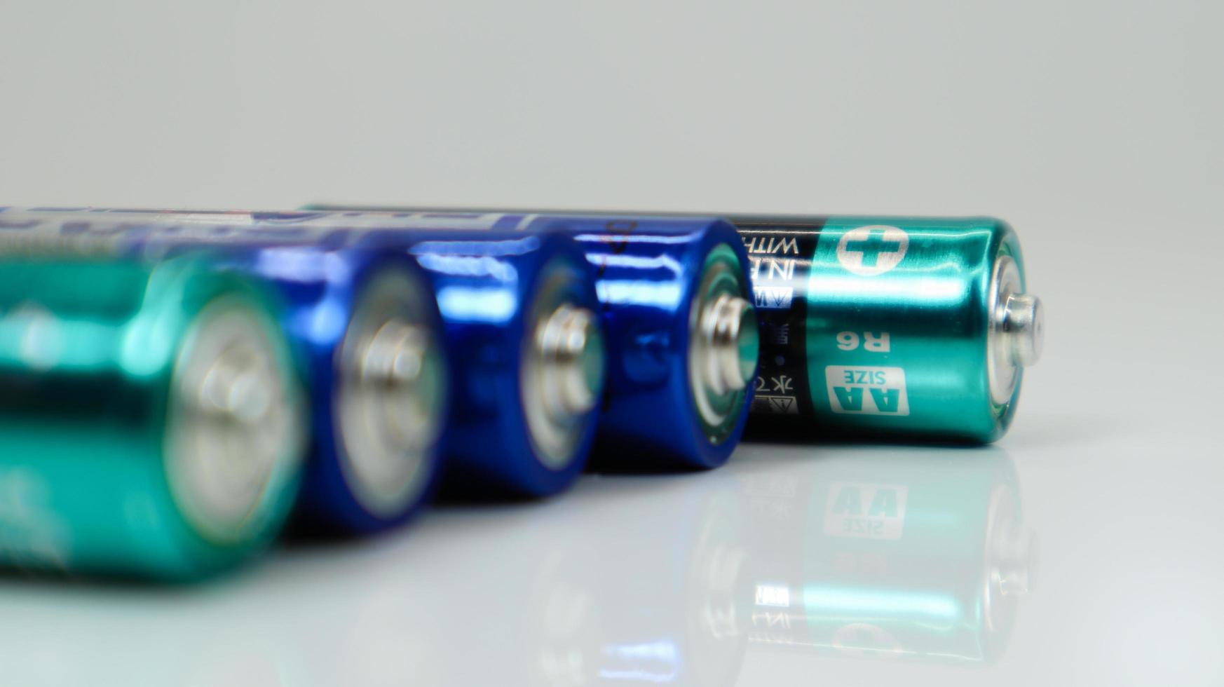 AA alkaline rechargeable batteries on white glossy background with reflection with copy space. photo