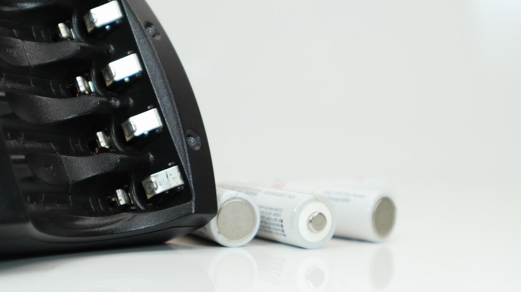 Fast charger for four AA rechargeable batteries in black on a white background. No batteries. photo