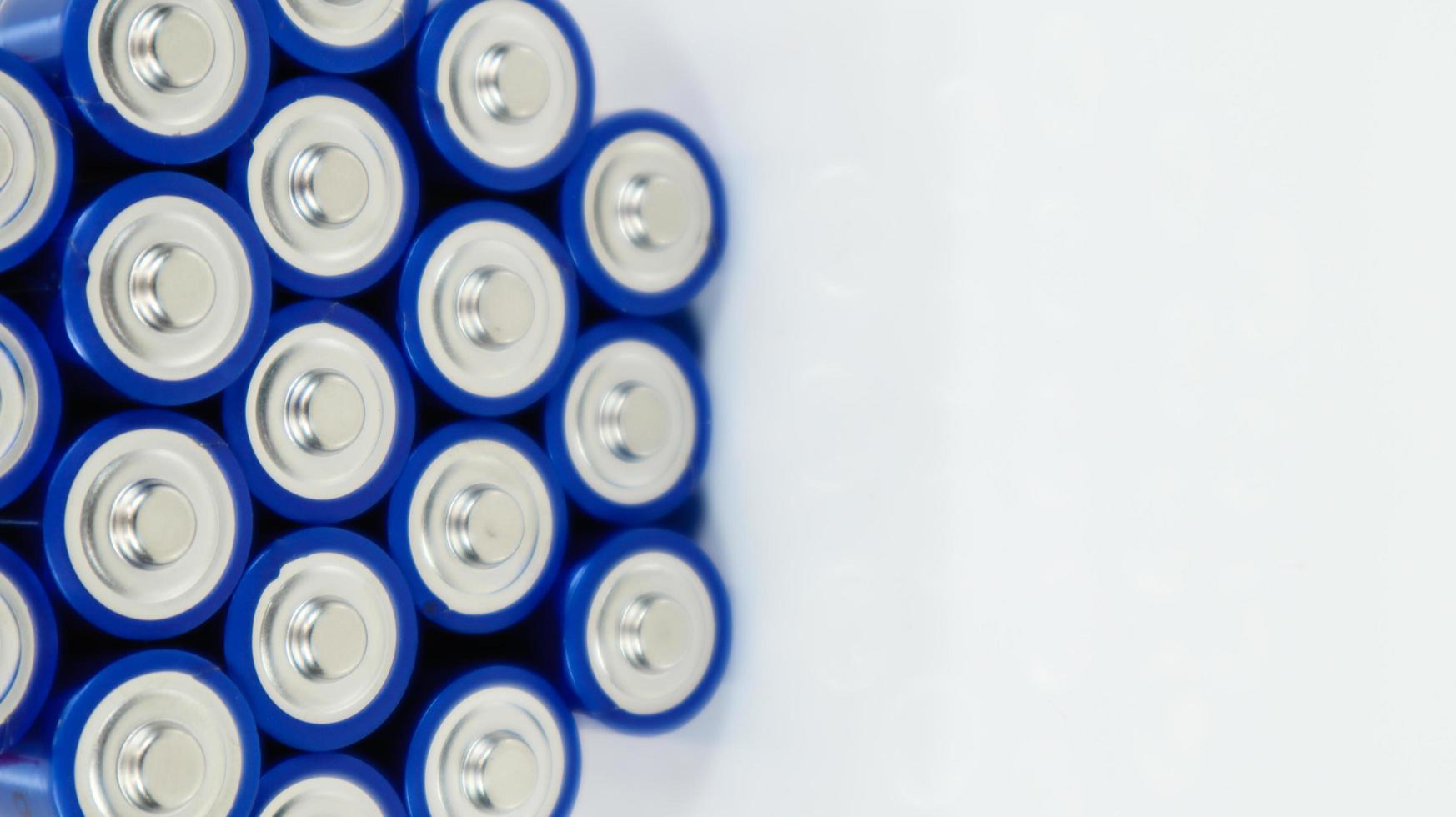 Lots of AA and AAA alkaline batteries on a white background. Ecological recycling concept. The terminals of the disposable batteries are close together and form a beautiful backdrop. Energy source. photo