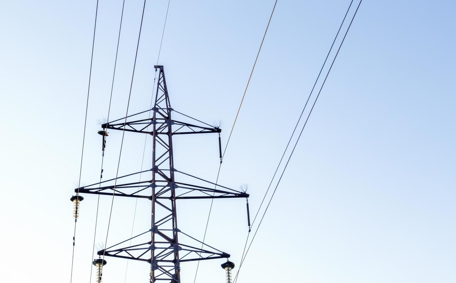 High voltage power lines, post or tower against the backdrop of a beautiful sky. Sequentially ordered high energy pylons. photo