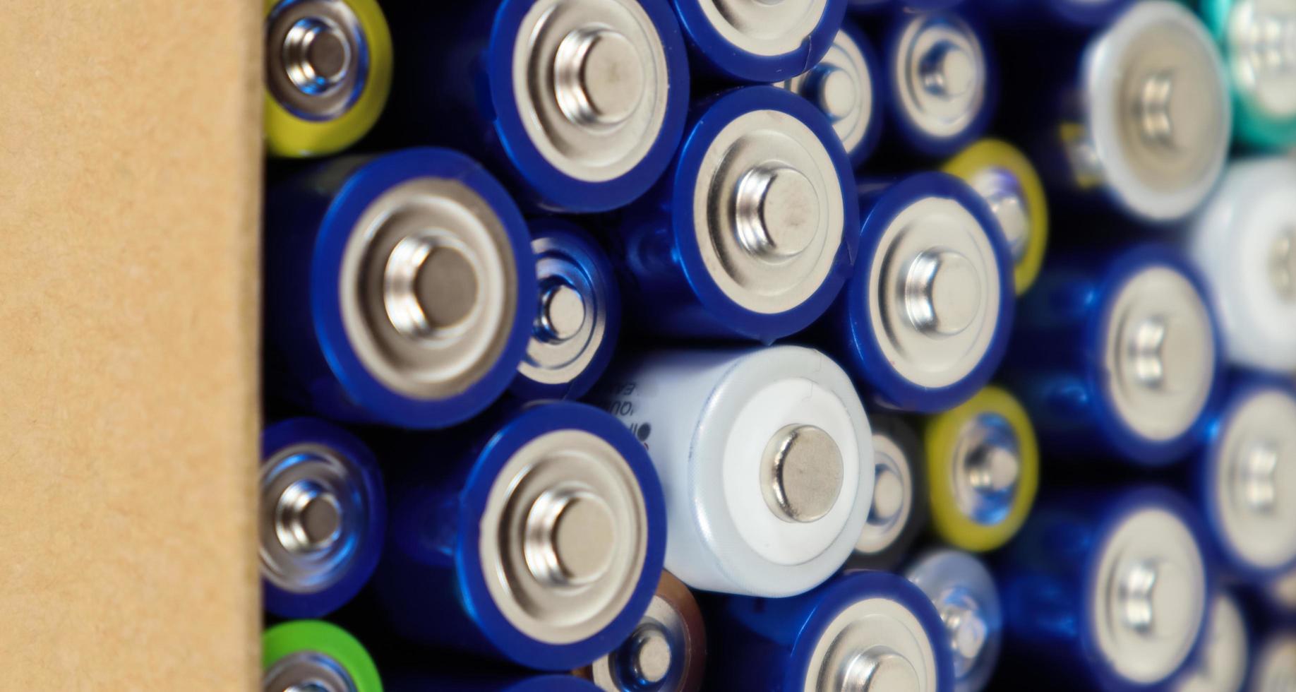 Background view of AAA AA batteries and rechargeable batteries. Choice of batteries. Energy supply and recycling concept. Textures of electrical elements packed close to each other. photo