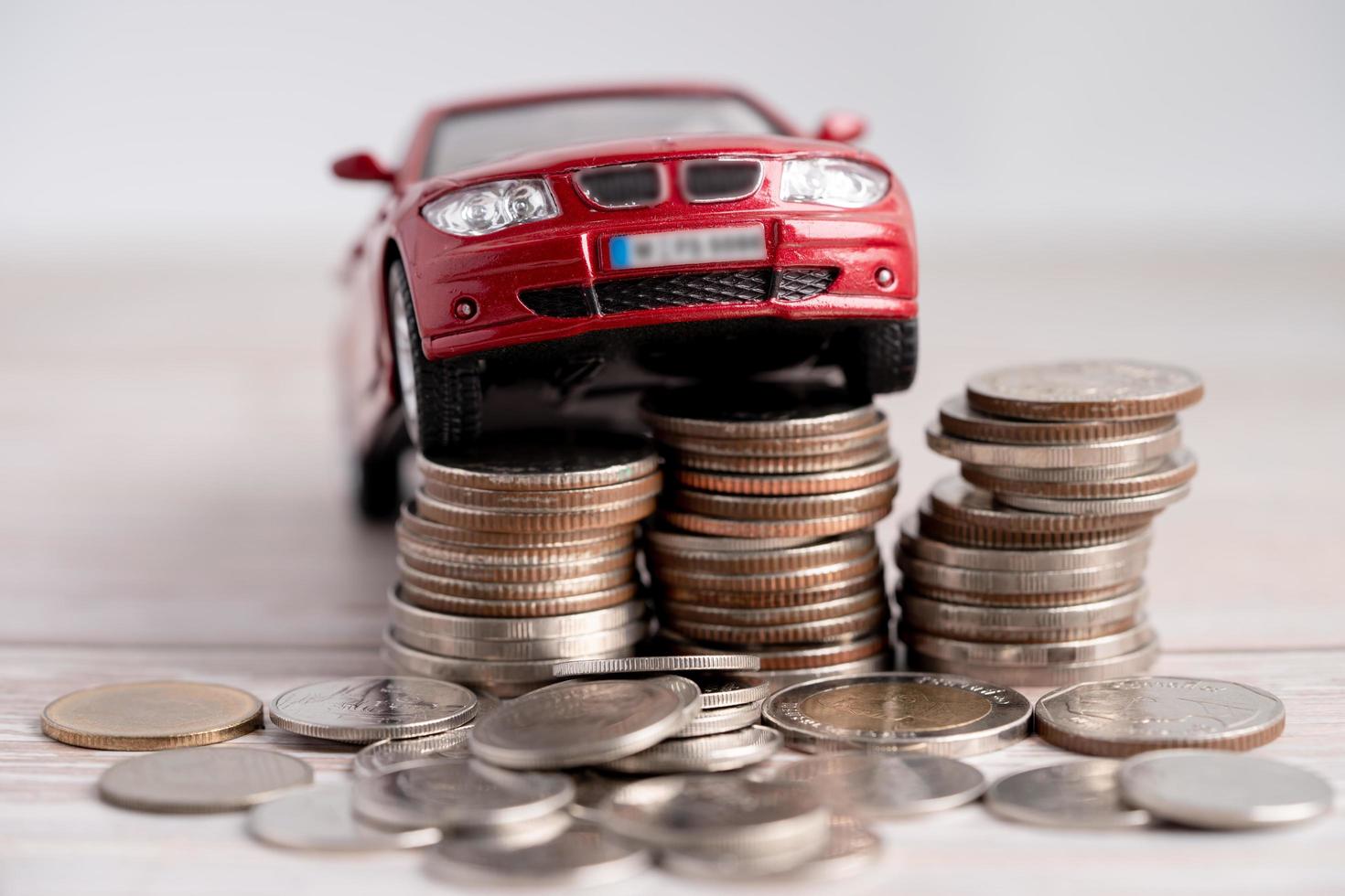 Car on stack of coins. Car loan, Finance, saving money, insurance and leasing time concepts. photo