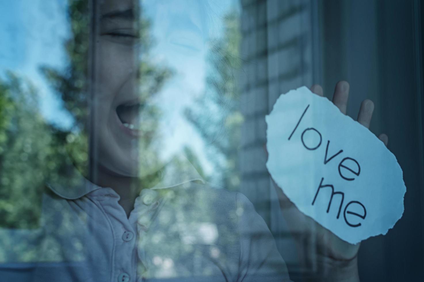 girl crying at the window with a note in his hand photo