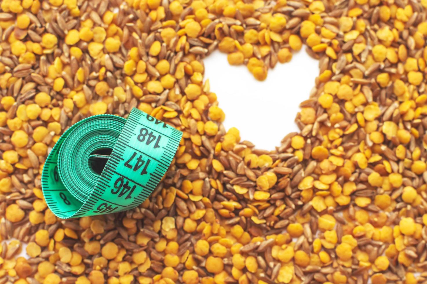 lentils and spelt with a centimeter ribbon on a white background. The concept of losing weight and fighting excess weight. Healthy diet. photo