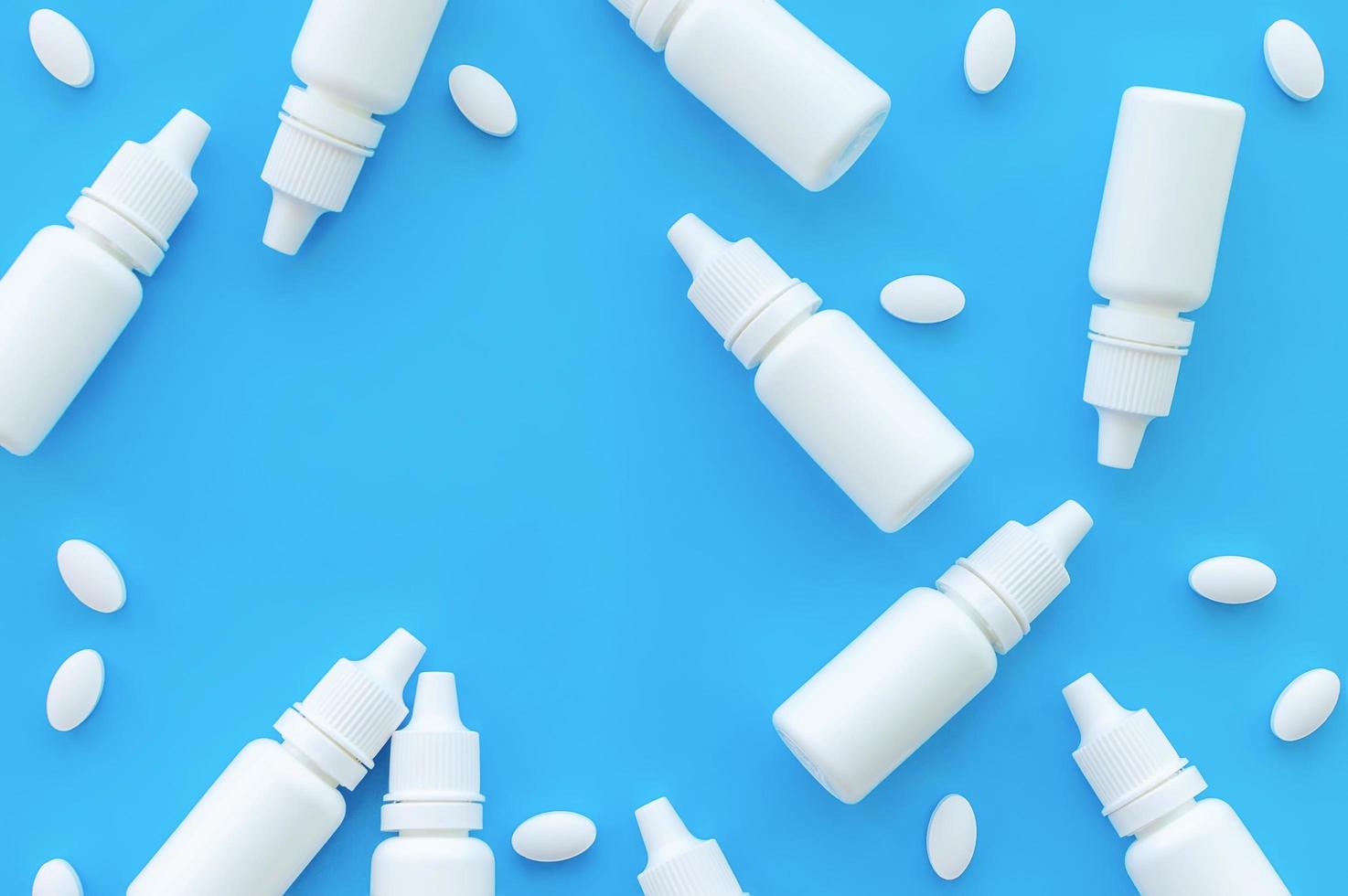Bottles with nose drops and pills on a blue background with a place for writing. The view from the top. photo