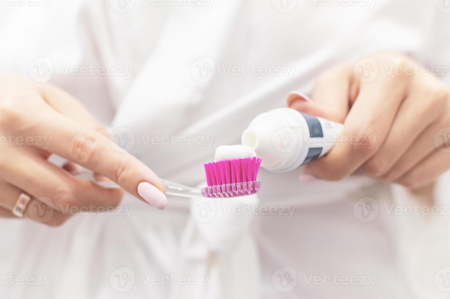 chica unta pasta de dientes en un cepillo. de cerca. enfoque selectivo. grano de la película. foto