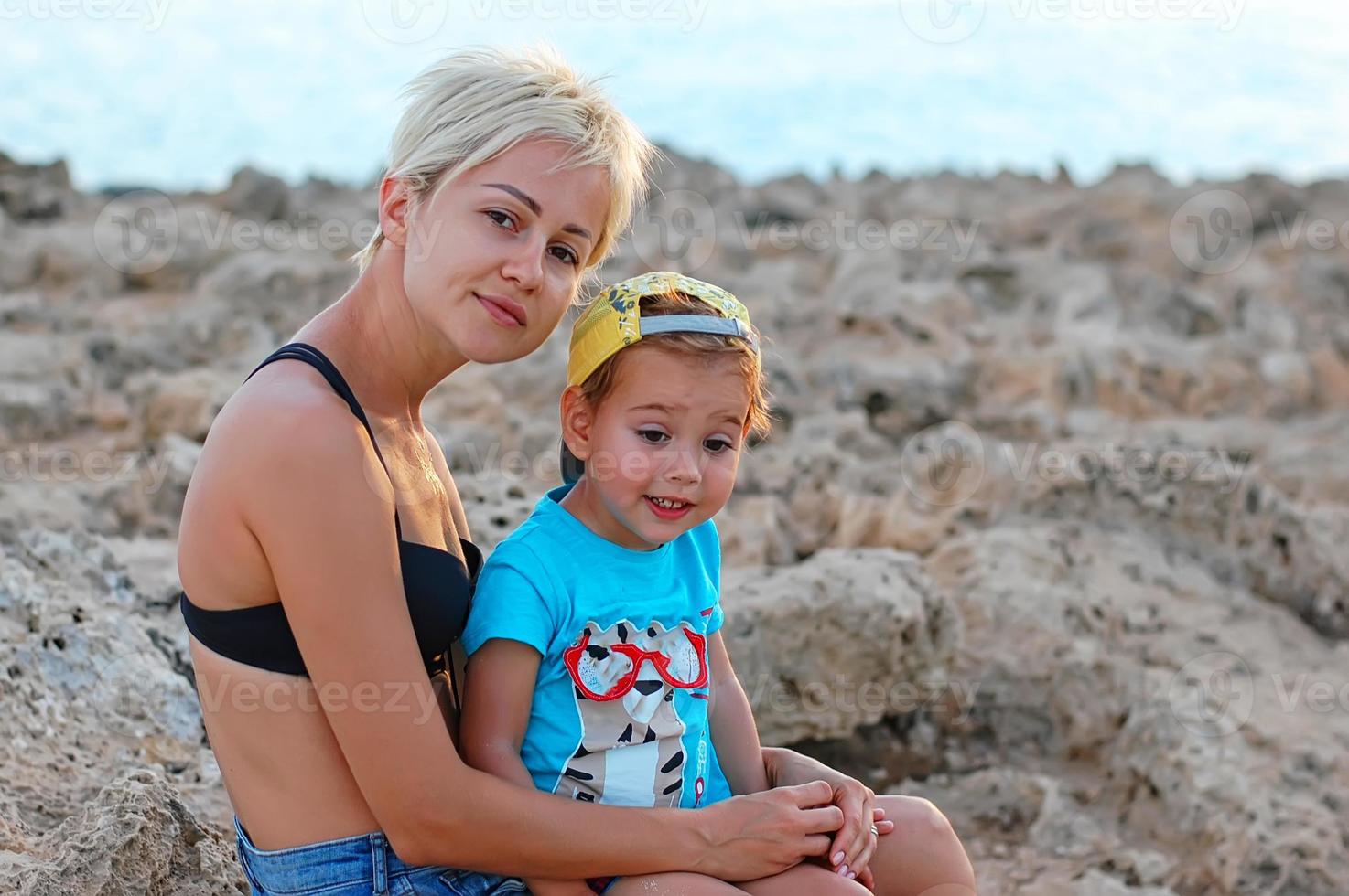 madre e hijo en la playa en un día soleado. turismo, viajes, vacaciones en familia. foto