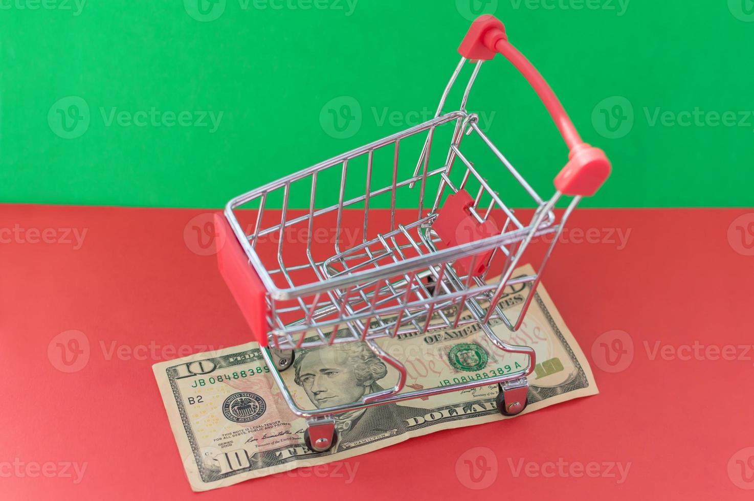 A shopping basket filled with medicines stands on a banknote on a red-green background. The concept of inflation and purchasing power. photo