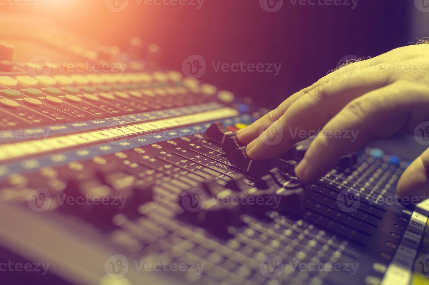 mano humana en la mesa de mezclas en el estudio de grabación. destacar. foto