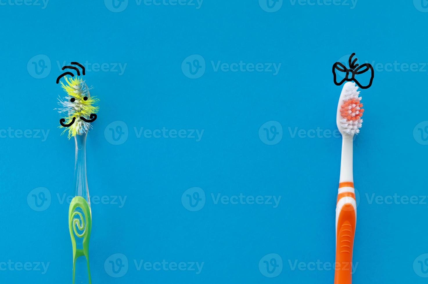 New and old toothbrush in the form of cartoon characters on a blue background. The view from the top. The concept of dental health. photo