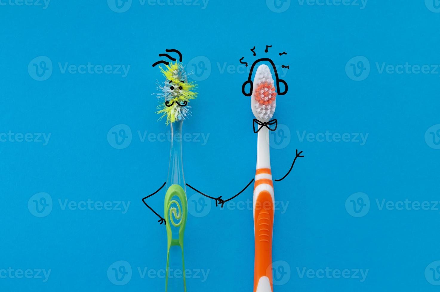 New and old toothbrush in the form of cartoon characters on a blue background. The view from the top. The concept of dental health. photo