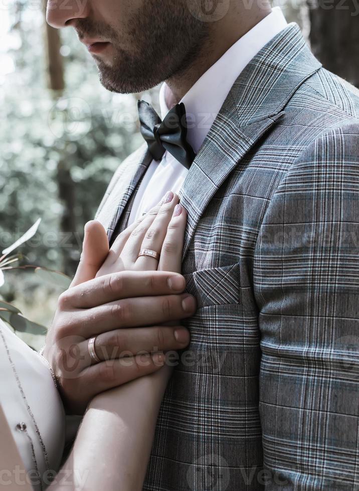 el novio sostiene la mano de la novia sobre su pecho el día de la boda. juramento. de cerca. enfoque selectivo. grano de la película. foto