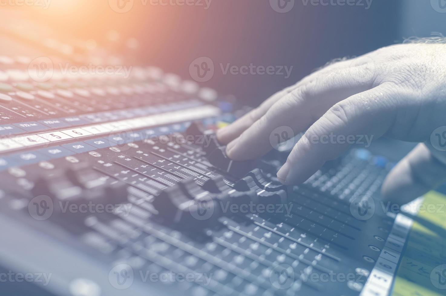 Human hand on the mixing console in the recording Studio. Spotlight. photo