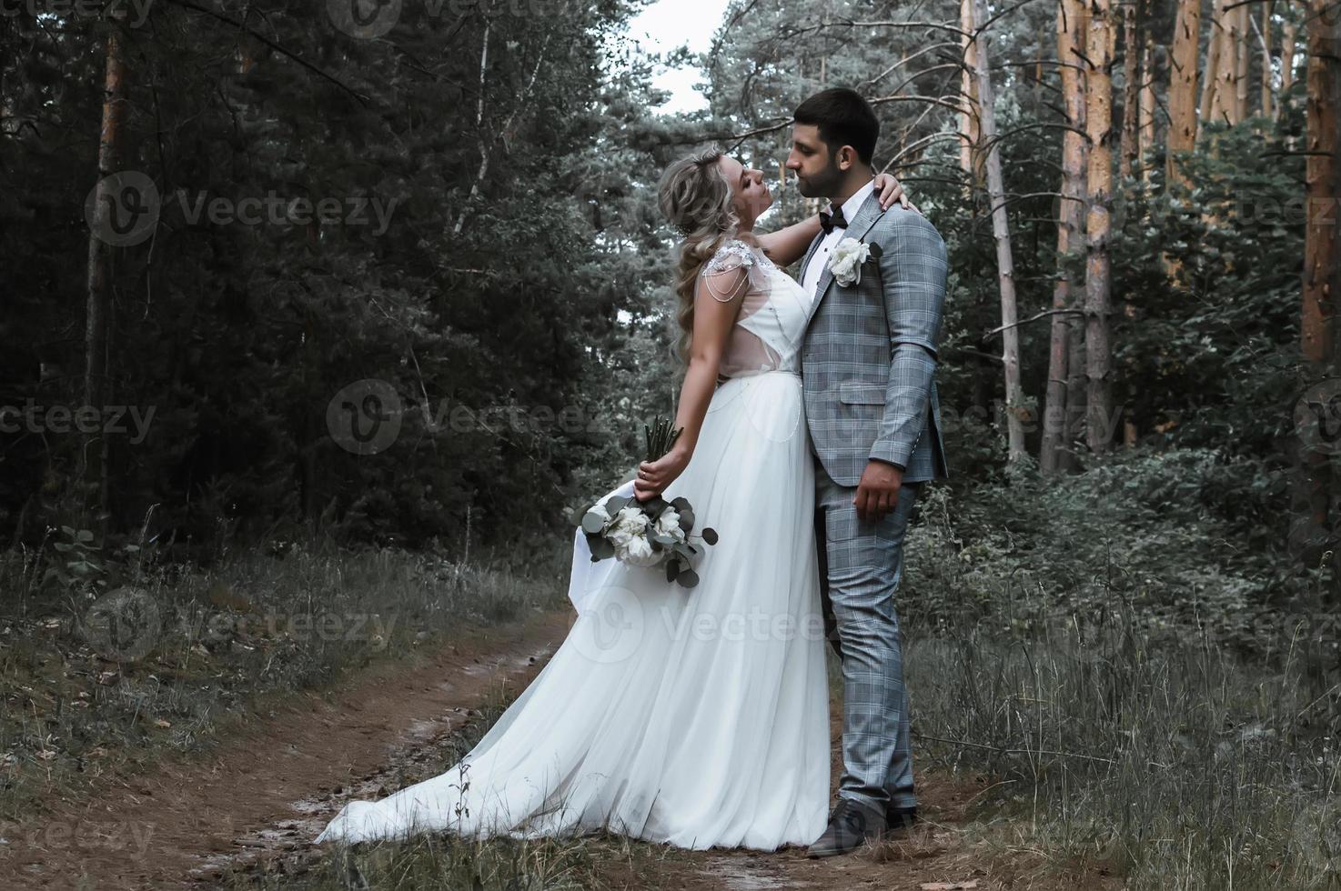 los novios se abrazan en el bosque el día de la boda. ceremonia de la boda. enfoque selectivo. grano de la película. foto