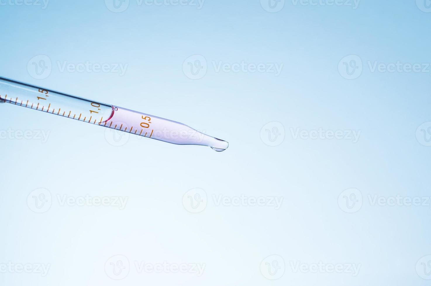 Medical laboratory. Pipette with pink liquid on a blue background. Laboratory tests. photo