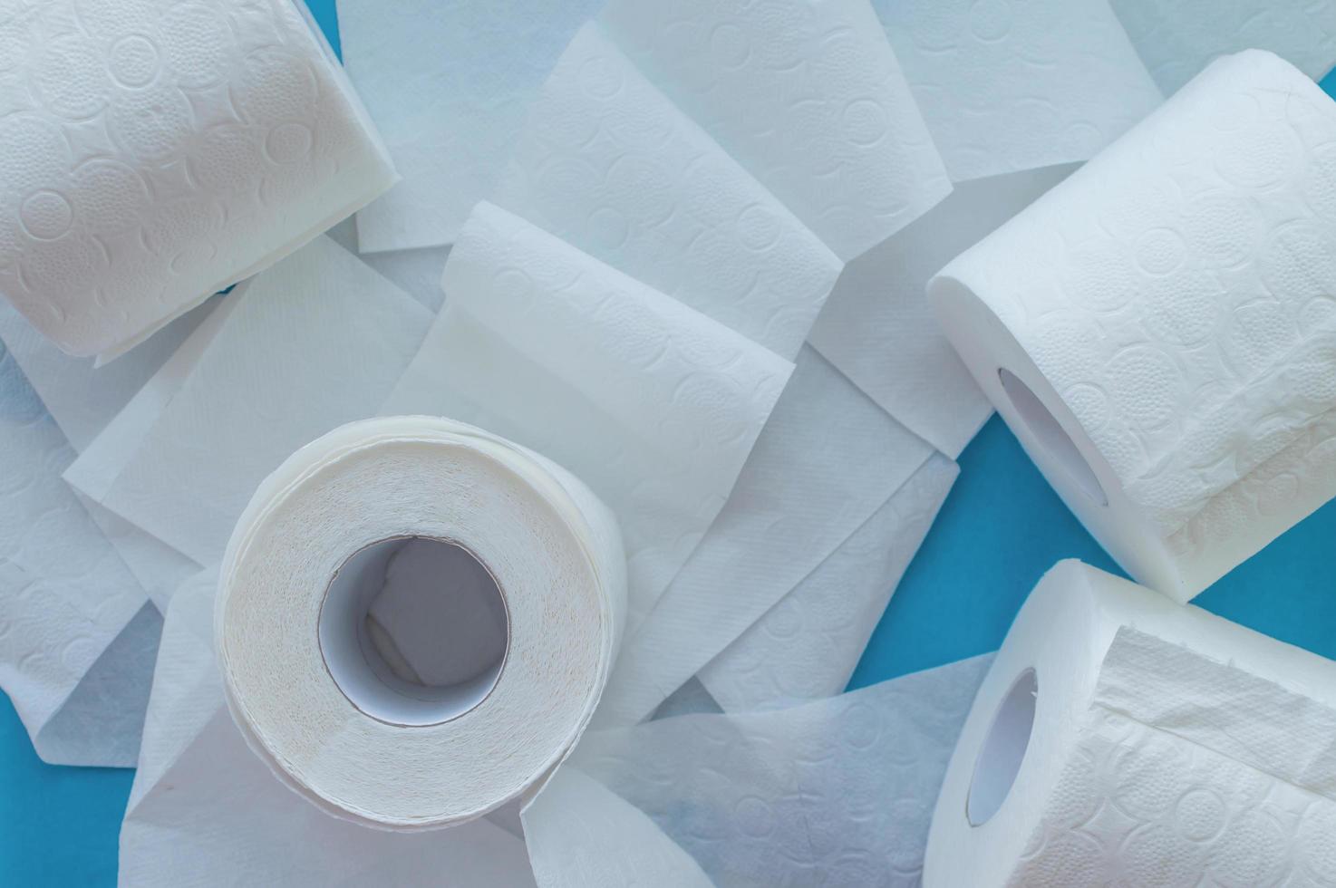 Rolls of white toilet paper on a blue background. Close up. The view from the top. photo