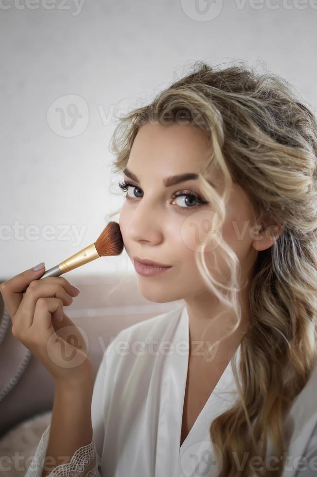 la novia hace el maquillaje de boda el día de la boda antes de la ceremonia. enfoque selectivo. grano de la película. foto