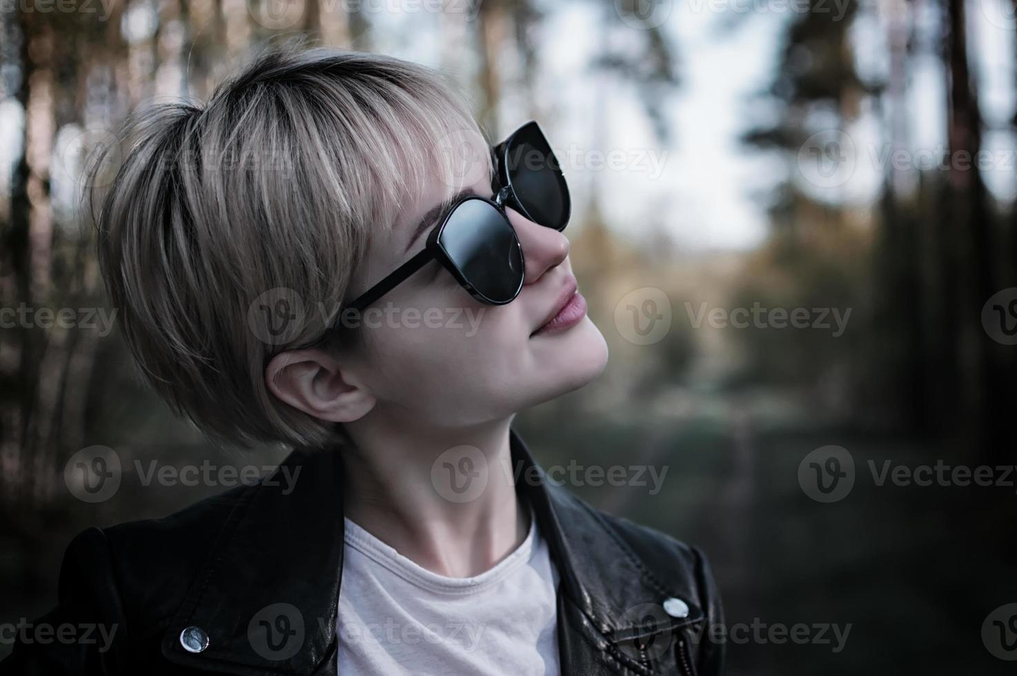 girl in sunglasses in the forest photo