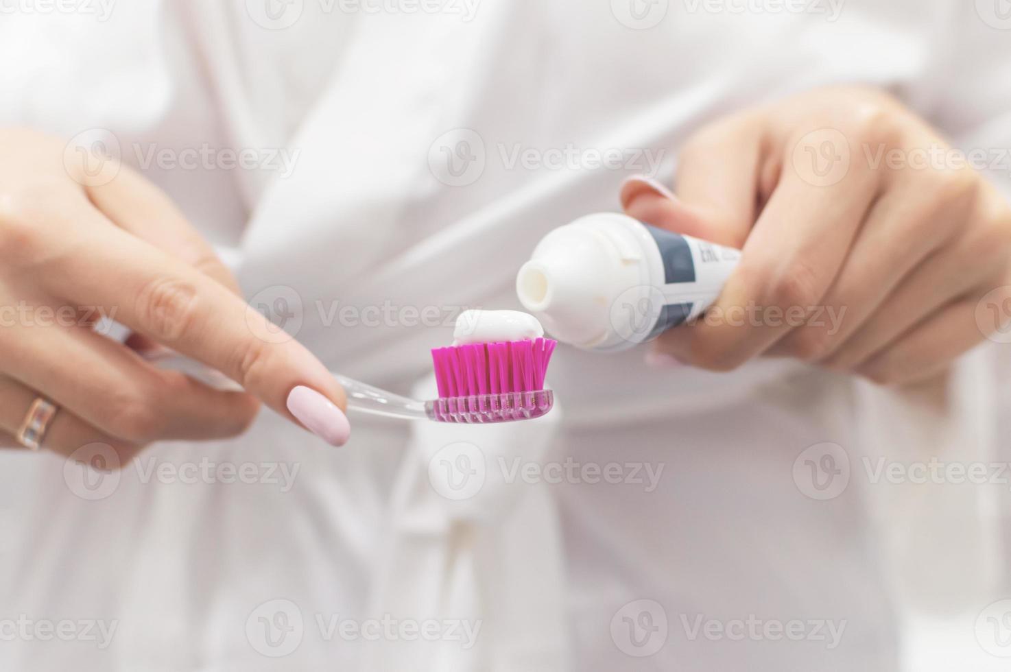 girl smears toothpaste on a brush. close-up. selective focus. film grain. photo